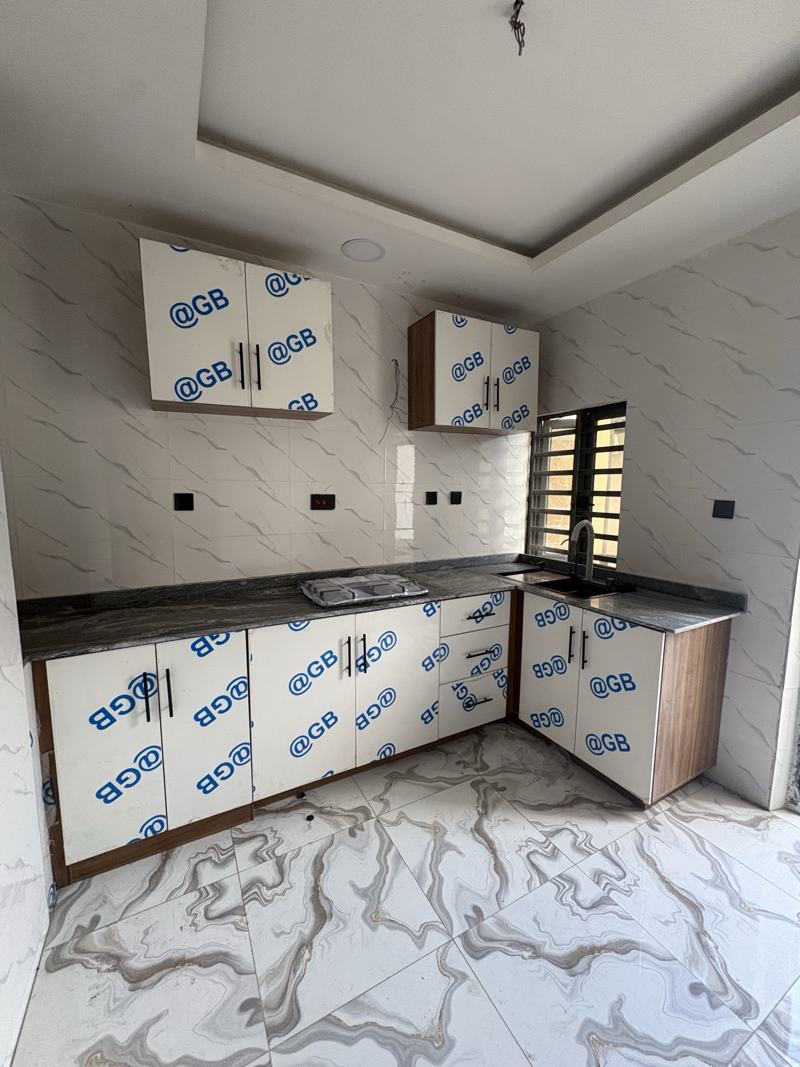 Fitted kitchen with granite worktop and marble wall tiles