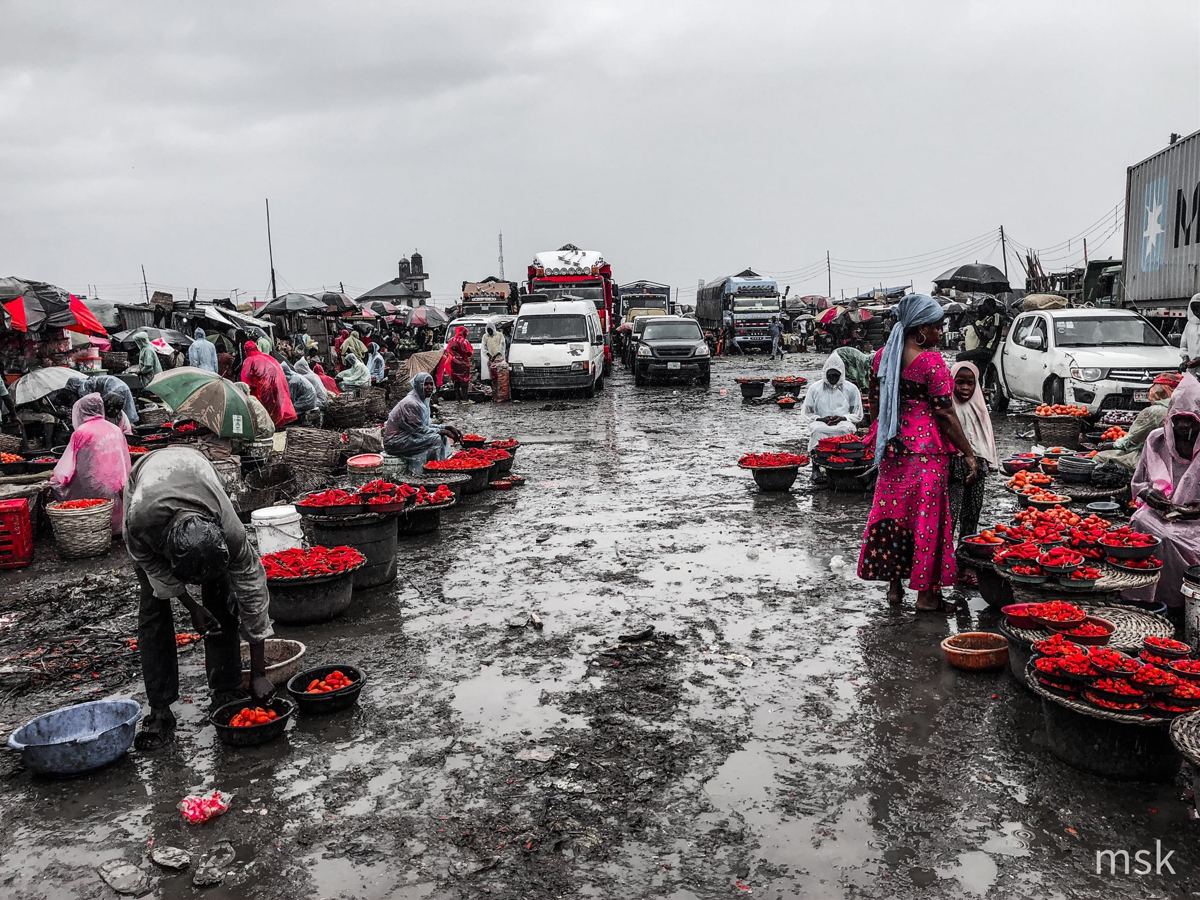 Rainy market with red peppers and pink clothing as the only colour